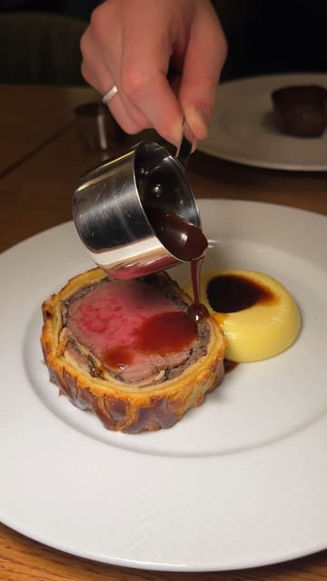 A polished, high-quality montage showcasing the new menu at a Cardiff brasserie. The video features close-up shots of dishes like Beef Wellington, fried chicken, mac and cheese, and creme brulee, interspersed with a brief shot of the bar area. The editing is rhythmic and professional, focusing entirely on the food presentation.
