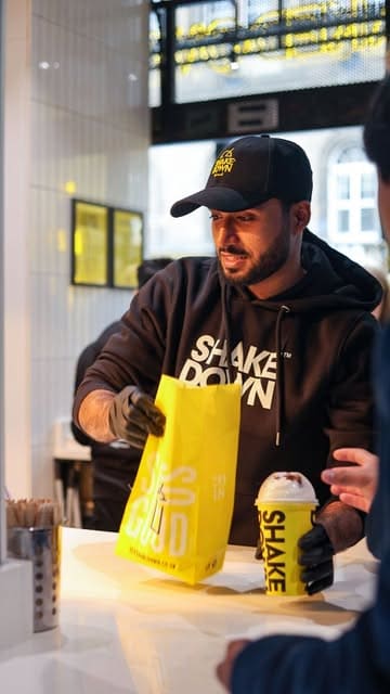 A promotional montage capturing the opening day of a new Shakedown burger venue in Edinburgh, showcasing the busy atmosphere, staff preparation, and the food.