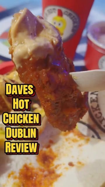 A review of Dave's Hot Chicken in Dublin, featuring close-ups of the chicken sliders, tenders, fries, and dipping sauce, along with shots of the restaurant's interior and branding.