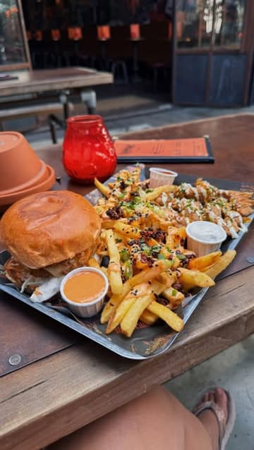 A short, energetic review of a vegan chicken venue in London Fields, featuring close-ups of plant-based 'chkn' bites, a pickle margarita, and a hot honey burger.