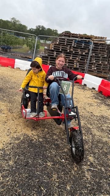 A montage of a family day out at Cammas Hall Farm, featuring various activities like a dinosaur show, meeting Disney princesses, riding pedal carts, driving mini diggers, and enjoying pizza and ice cream.