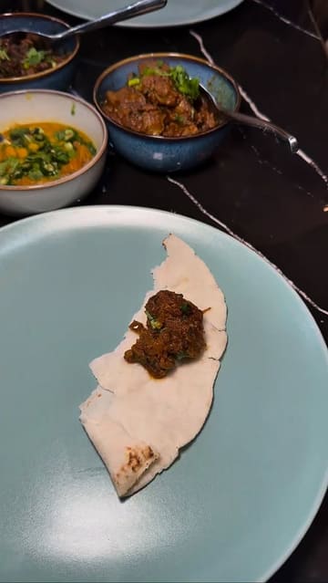 A vlog-style review of a £10 lunch deal at a restaurant called Pach Bhai, featuring a variety of traditional dishes like beef bhuna, daal, and chicken liver.