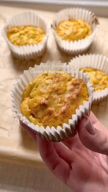 A concise, step-by-step recipe video demonstrating the preparation of baby-friendly carrot and banana muffins. The video uses text overlays to guide the viewer through the mixing and baking process.