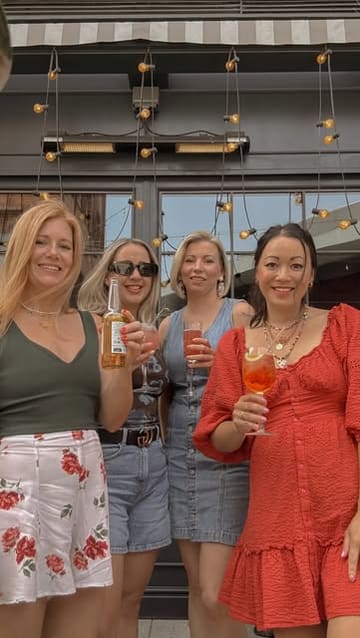 A group of friends visits Flight Club, enjoying cocktails and food on the terrace before heading inside to play darts.