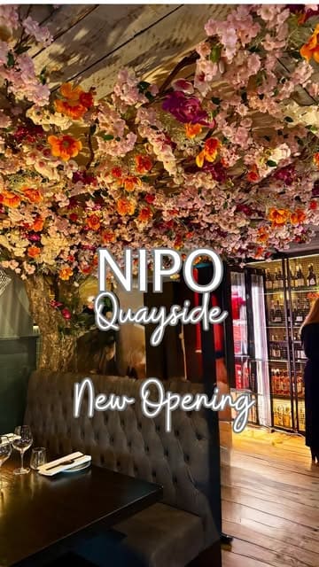 A promotional video for NIPO restaurant, featuring a montage of the interior, staff service, cocktail preparation, and various dishes including sushi and beef.