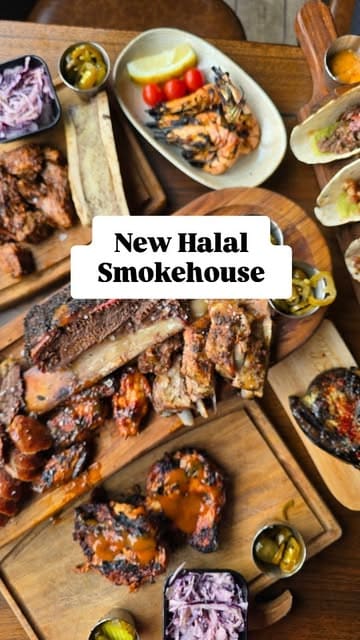 A high-quality, overhead flat-lay shot showcasing a generous spread of American-style BBQ dishes, including smoked meats, ribs, and sides, presented on wooden boards.