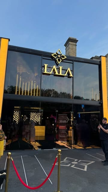 A promotional reel for Lala's restaurant in Bradford, showcasing the elegant interior decor, including a large cherry blossom tree, and a variety of dishes including naan, curry, biryani, and dessert.