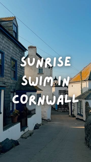 A serene, early-morning shot of a quiet street in Port Isaac, Cornwall, capturing the peaceful atmosphere of a sunrise swim. The composition effectively uses the leading lines of the street to draw the viewer into the scene, while the soft, golden-hour lighting enhances the charm of the coastal village.