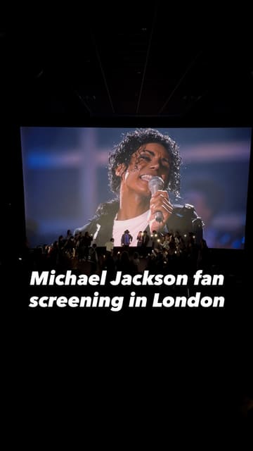A short, handheld video capturing the atmosphere inside a cinema during a Michael Jackson fan screening in London. The footage shows the audience singing along and waving phone lights, highlighting the communal and energetic nature of the event.