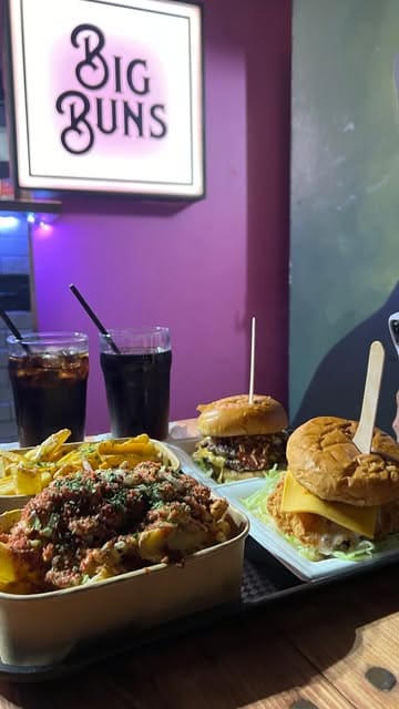 A short, energetic montage showcasing a visit to Big Buns in Leeds, featuring close-ups of smash burgers, various loaded fries, and drinks.