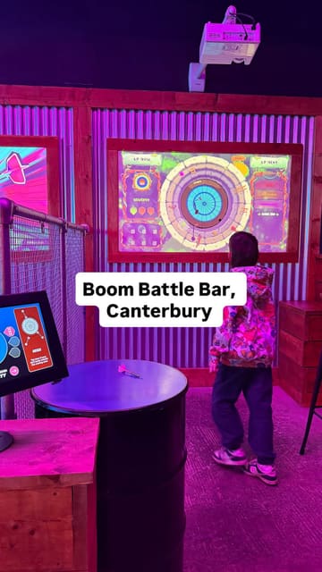 A fast-paced promotional video for Boom Battle Bar in Canterbury, highlighting the activity bundle which includes games like AR darts, mini golf, and karaoke, alongside food and drinks.