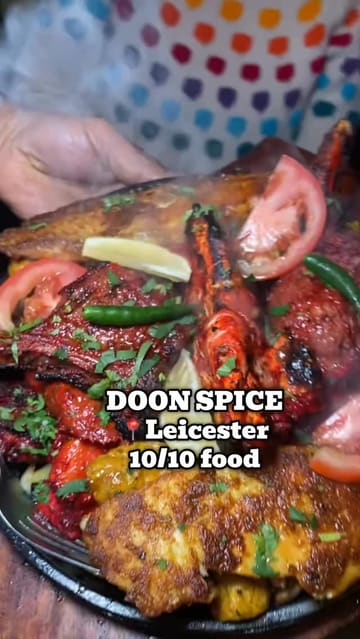 A fast-paced, vlog-style review of Doon Spice in Leicester. The video features a montage of various dishes including sizzling platters, curries, and naan, interspersed with shots of the chef cooking and the creator enjoying the food. The voiceover provides enthusiastic commentary on the quality of the meal.