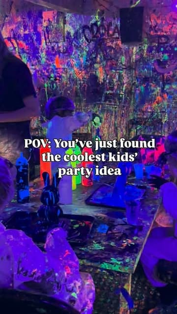 A high-energy reel showcasing a fluid art party experience for children at a studio, highlighting the creative activity, the protective gear provided, and the freedom for kids to paint the walls.