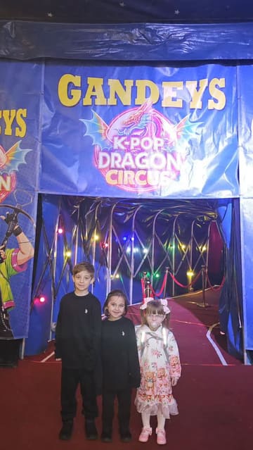 A family-focused vlog documenting a visit to Gandey's K-Pop Dragon Circus. The video features clips of the children interacting with the venue's entrance, watching the circus performances, and enjoying snacks like fries, popcorn, and candy floss.