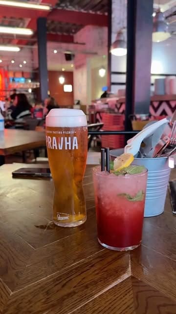 A video review of Pizza Punks in Newcastle, highlighting their Thursday deal which includes a pizza, side, and drink for £24.50 per person. The creator showcases the interior, the menu, and various dishes including a smash burger pizza, buffalo chicken pizza, mac and cheese, and a garlic bomb, alongside a strawberry smash cocktail.