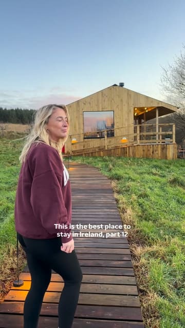A couple shares their stay at 'The Bothans', a cabin in Ireland, highlighting the cozy interior, outdoor hot tub, scenic views, and relaxing activities like board games and cooking.