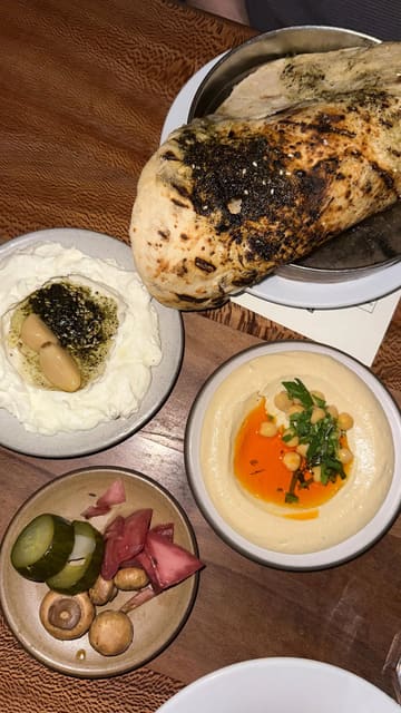 A short, energetic reel showcasing the £39 set menu at Bubala, featuring close-ups of various vegetarian Middle Eastern dishes like hummus, labneh, halloumi, and potato latkes, alongside shots of the kitchen and dining atmosphere.