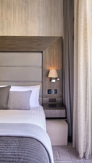 A tour of a boutique hotel room in London, highlighting the room's features, technology, bathroom, and balcony, ending with a tea service.