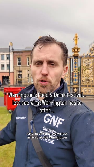 A vlog-style review of the Warrington Food & Drink Festival, featuring the creator walking through the event, sampling various street food items like a sausage roll, halloumi fries, and a loaded hot dog, while commenting on the atmosphere and the impact of the rainy weather.