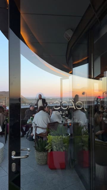 A short, atmospheric montage showcasing a rooftop bar and restaurant at sunset. The video features shots of the venue's exterior and interior, groups of friends enjoying drinks and small plates, and close-ups of sushi and cocktails. The editing is rhythmic and aligns with the music, creating an inviting and trendy vibe suitable for social gatherings.