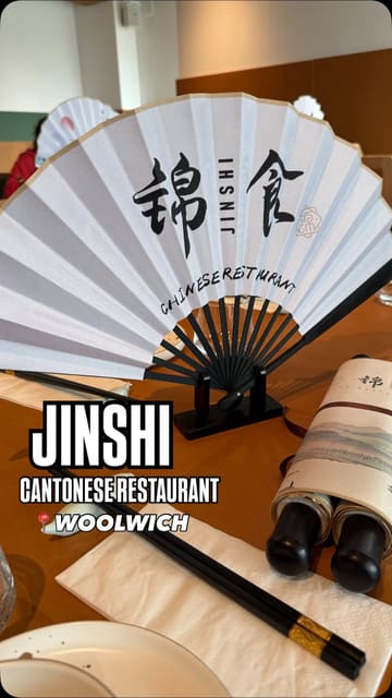 A review-style video showcasing a visit to Jinshi, a modern Chinese restaurant in Woolwich. The video features the exterior, the cozy interior, the menu, and a variety of dishes including dumplings, shredded beef, black bean pepper beef, roasted meats, and noodle soup.
