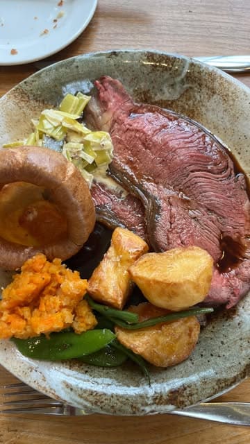 A montage showcasing a Sunday lunch experience at Congham Hall in Norfolk, featuring cocktails, a roast beef dinner, a fish dish, and desserts.