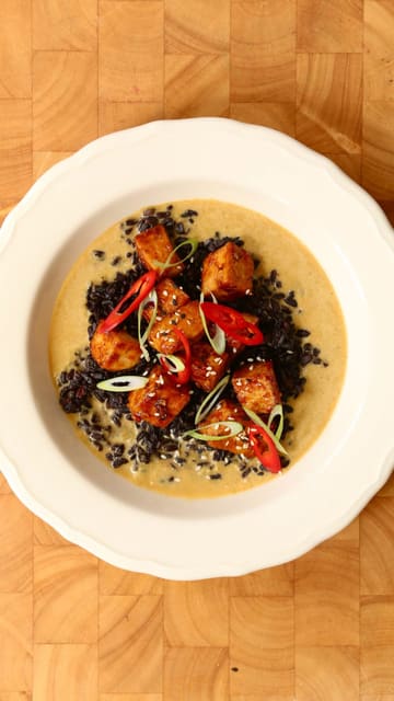 A high-quality recipe tutorial video demonstrating how to make a coconut, lemongrass, and tofu curry. The video features the creator introducing the dish, followed by clear, step-by-step cooking shots, and concludes with the final plated result.