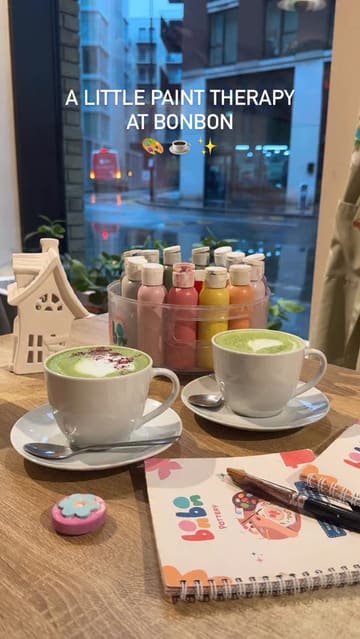 A short, aesthetic montage showcasing a pottery painting session at a cafe. The video follows the process from selecting a ceramic piece to painting it, while enjoying a matcha latte, and concludes with the finished items.