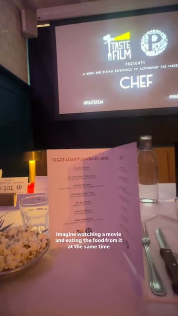 A first-person vlog documenting a 'Taste Film' event where the viewer watches the movie 'Chef' while eating a themed, plant-based menu. The video features various dishes served during the film, including a Cuban sandwich, pasta, and lava cake, providing a glimpse into the immersive dining experience.