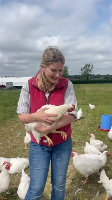 A personal vlog-style video featuring a woman on a farm discussing self-sufficiency and sourcing poultry. The video includes shots of the farm, the chickens, the preparation of meat, and a finished roasted chicken on a BBQ.