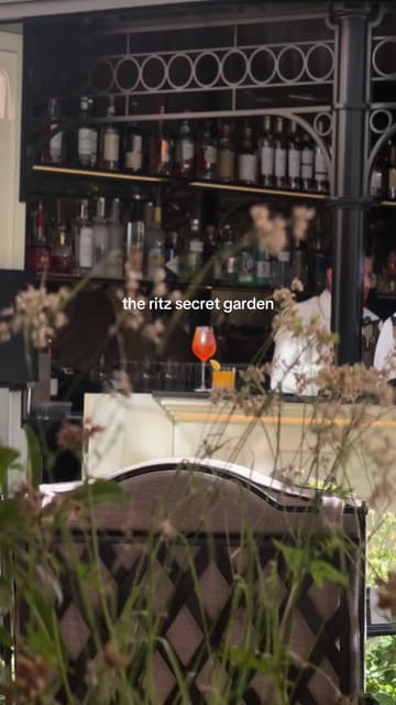 A high-quality, aspirational video showcasing the 'Secret Garden' at The Ritz London. The footage captures the elegant outdoor terrace, the sophisticated atmosphere, and a variety of high-end dishes and cocktails, including wagyu sando with caviar, pasta, and desserts. The video effectively uses a vlog-style perspective to guide the viewer through the experience, from lunch to evening drinks.