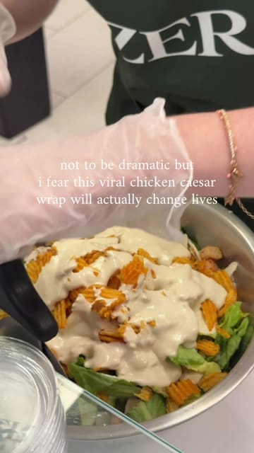 A short, engaging video showing the preparation of a chicken caesar wrap at a venue in Mayfair, including the addition of crisps.
