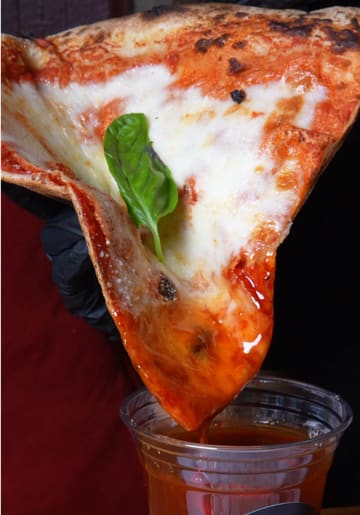 A promotional video for The Big Slice in Paisley, featuring a creator introducing the venue and showcasing their large pizza slices, dipping sauces, fries, and milkshakes.