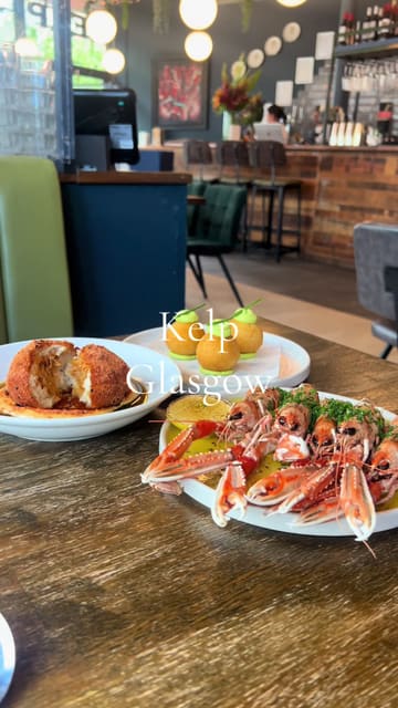A montage-style video showcasing a variety of seafood-focused dishes at Kelp in Glasgow. The video features close-up shots of plates like langoustines, crab donuts, and Arbroath smokie croquetas, interspersed with shots of a diner enjoying the experience.