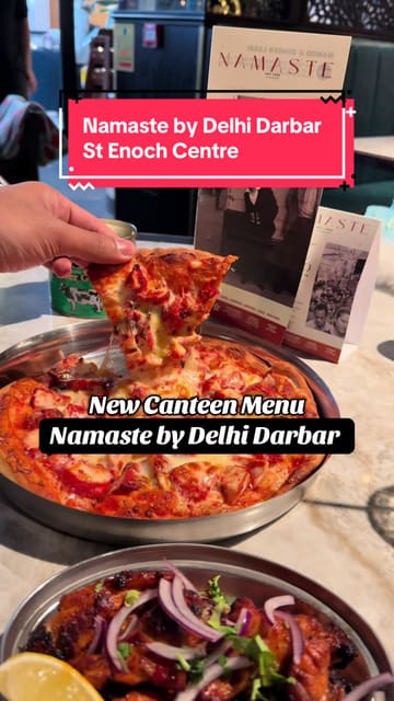 A short, energetic promotional video for the new canteen menu at Namaste by Delhi Darbar. The video features quick cuts of various dishes including a chicken pakora naan wrap, a baked potato, and a pizza naan, alongside shots of the venue interior and the pouring of masala chai.
