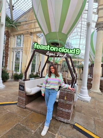 A short video showcasing the Feast on Cloud 9 afternoon tea experience located within the Syon Park conservatory. The video features the unique dining setup where tables are housed inside decorative hot air balloon structures, followed by shots of the afternoon tea spread, including sandwiches, scones, and desserts.