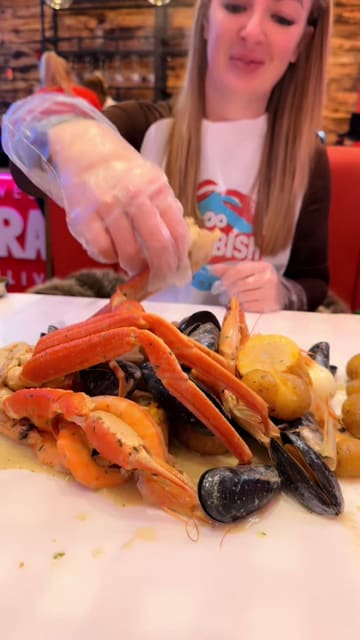 A review of a new seafood boil restaurant in Liverpool called Crabbish, highlighting the hands-on, messy dining experience and the 'Double Trouble' seafood platter.