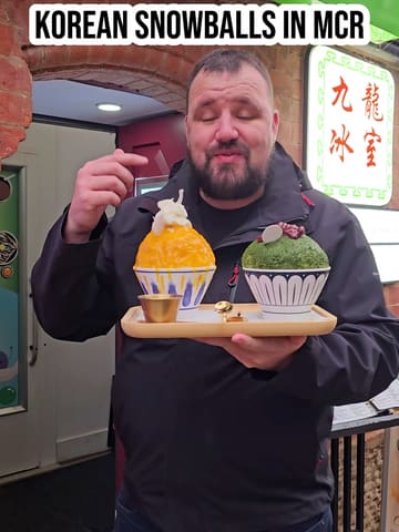 The creator visits 'Aftertaste' located within 'Dragon Oriental' in Manchester's Chinatown to review their Korean Bingsu (snowballs). The video includes a demonstration of the preparation process, showing the layering of shaved ice, sauces, and toppings, followed by a taste test of the mango and matcha varieties.