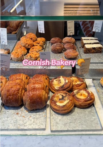 A short, upbeat video showcasing a visit to a Cornish Bakery location in Worcester. The video features close-ups of various pastries, a sandwich, and hot drinks, followed by a shot of the creator enjoying the food, and concludes with exterior shots of the bakery.