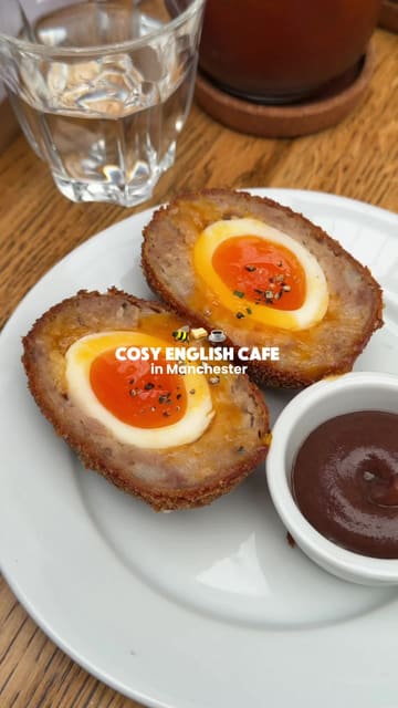 A short, engaging review of a cafe in Manchester's Northern Quarter, highlighting various British comfort food items including a Scotch egg, hash browns, and a Northern rarebit.