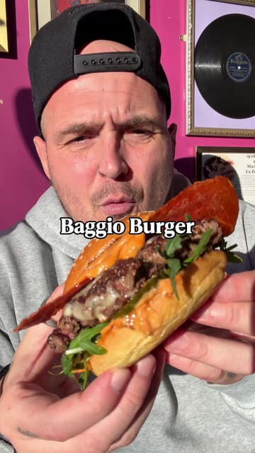 A creator reviews Baggio Burger, a street food residency at The Nags Head in Walthamstow. The video features close-ups of various menu items including the Baggio Burger, Maldini chicken burger, tiramisu wings, and parmesan fries, while the creator provides commentary on the flavours and quality. The video also gives a brief look at the pub's interior and atmosphere.
