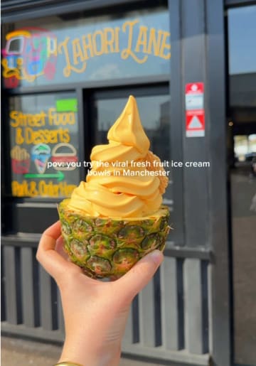 A short, rhythmic video showcasing the preparation and serving of soft-serve ice cream inside hollowed-out fresh fruits like pineapple, mango, watermelon, and dragonfruit at Lahori Lane in Manchester.
