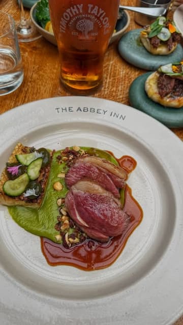 A group of friends visits The Abbey Inn at Byland, showcasing the historic location, the interior atmosphere, and a variety of dishes including charcuterie, sourdough, hogget, and a Guinness soft serve sundae.