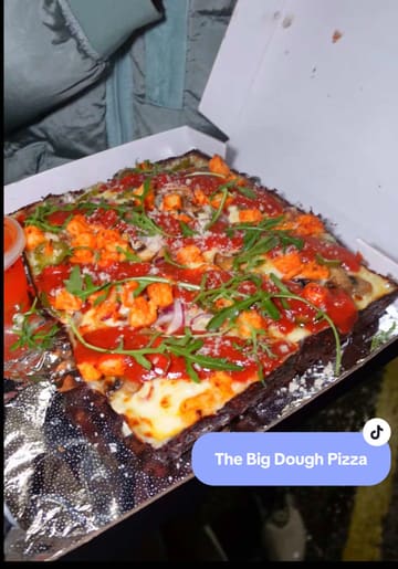 A creator reviews a Detroit-style pizza takeaway service called 'Big Dough' in Hamilton. The video features the creator ordering via an app, followed by a close-up taste test of a chicken tikka pizza and a pepperoni pizza, along with wings and fries, highlighting the quality of the crust and toppings.