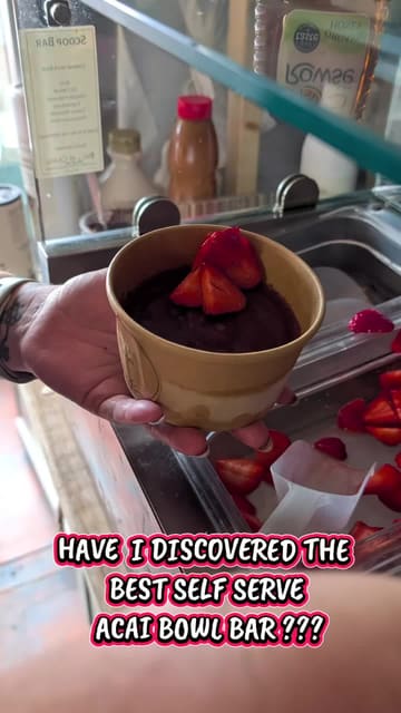 A short, first-person video showcasing a new self-serve acai bowl bar, highlighting the variety of toppings and additional dessert options like frozen yogurt and overnight oats available to customers.