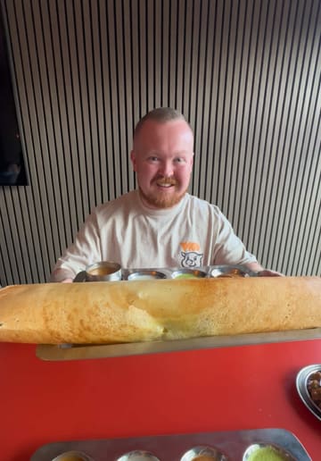 A couple visits a South Indian vegetarian restaurant called Pappu Dosa in Patchway, Bristol. They review several dishes including masala dosa, vada pav, samosas, and cauliflower manchurian, highlighting the fresh flavours and excellent value for money.