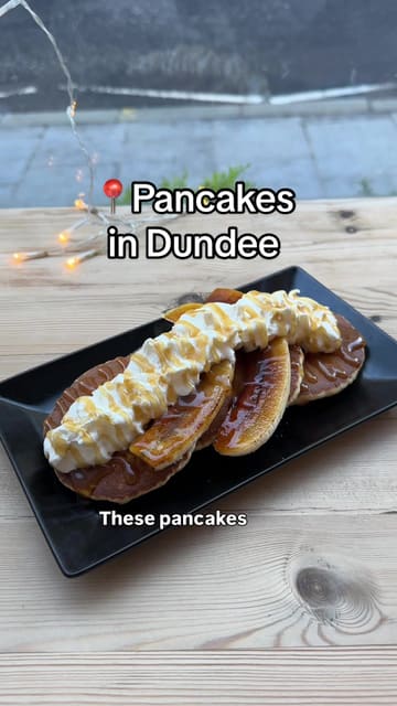 The creator visits three different venues in Dundee—Black Mamba, Jute Cafe, and Beans & Berries—to sample their pancake offerings using the Dundee Gift Card. The video follows a listicle format, showing the exterior of each venue, the payment process, and close-ups of the pancake dishes, with the creator providing commentary on each.
