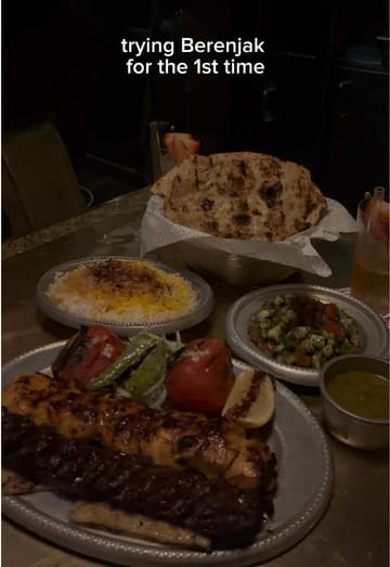 A vlog-style review of Berenjak, featuring a variety of Persian dishes including kebabs, dips, and fresh bread. The creator provides a voiceover commentary on the experience, including the wait time and pricing.
