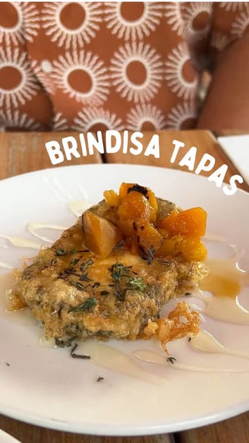 A montage of various Spanish tapas dishes, drinks, and the outdoor seating area of a restaurant, set to music.