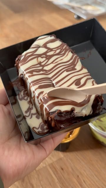 A short video showcasing three different dessert slices: a chocolate cake, a kunafa cake, and a Biscoff milk cake. The creator uses a wooden spoon to scoop and pull apart the desserts to show their texture.
